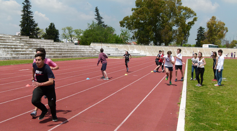 jóvenes universitarios corren 100 metros llanos en una pista de atletismo profesional